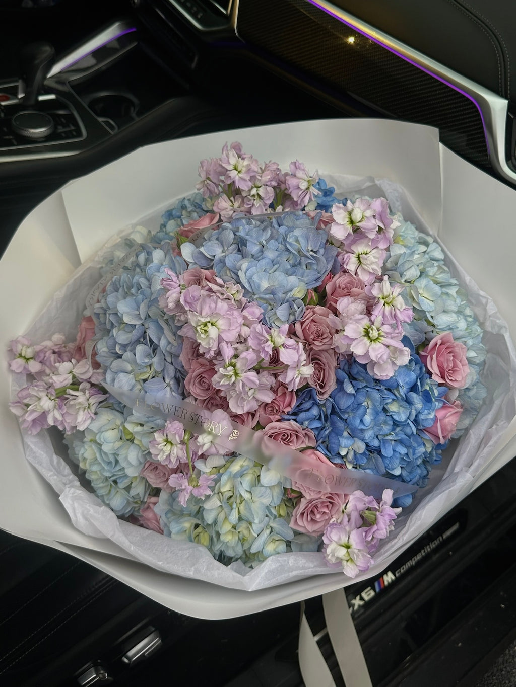 Mix bouquet of blue hydrangeas, purple spray roses & stock